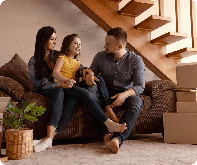 Família feliz no sofá - realize o sonho da casa própria